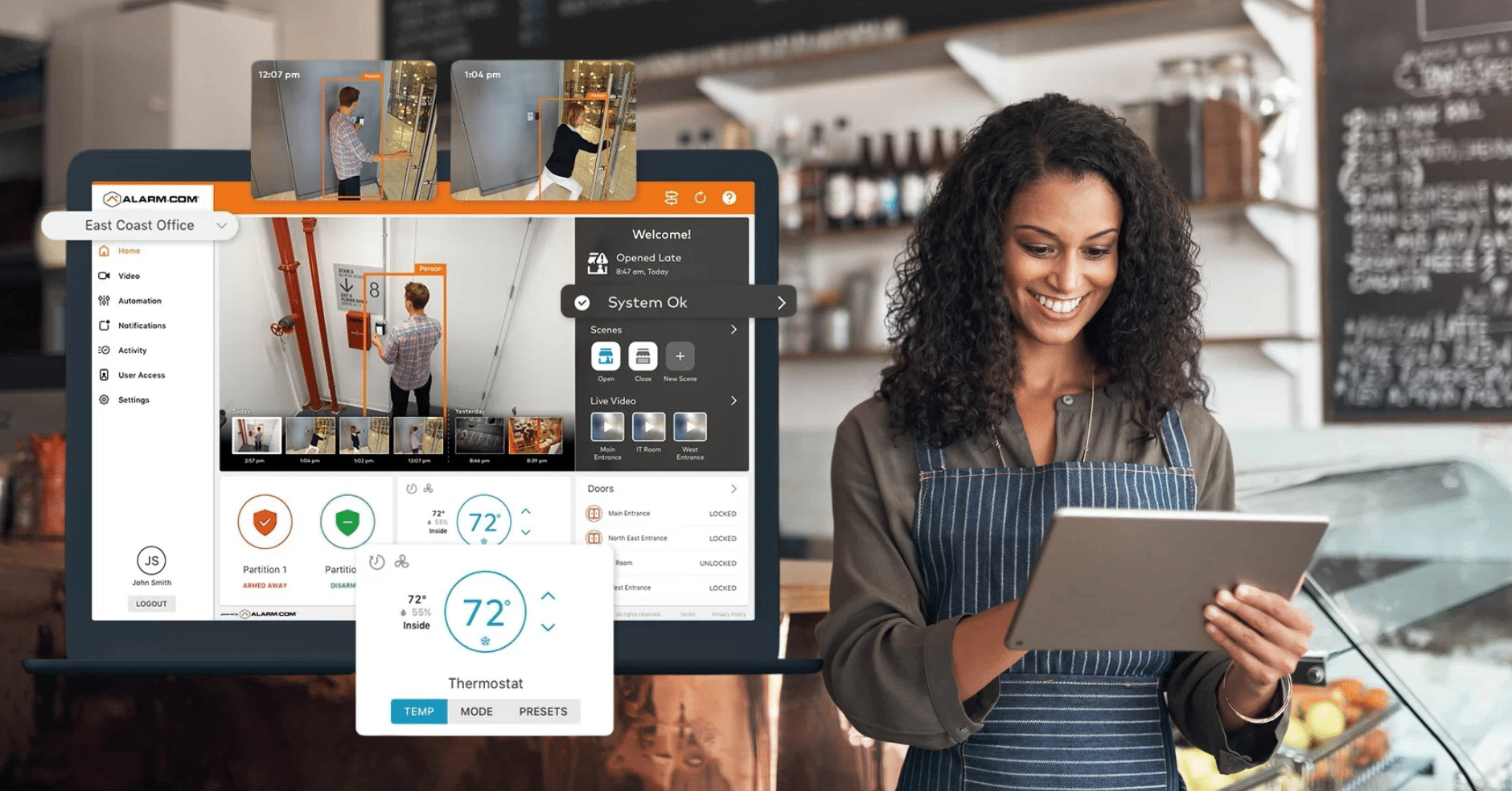 Smiling small business owner using a tablet to monitor her security system, displaying live video surveillance and environmental controls on the screen.
