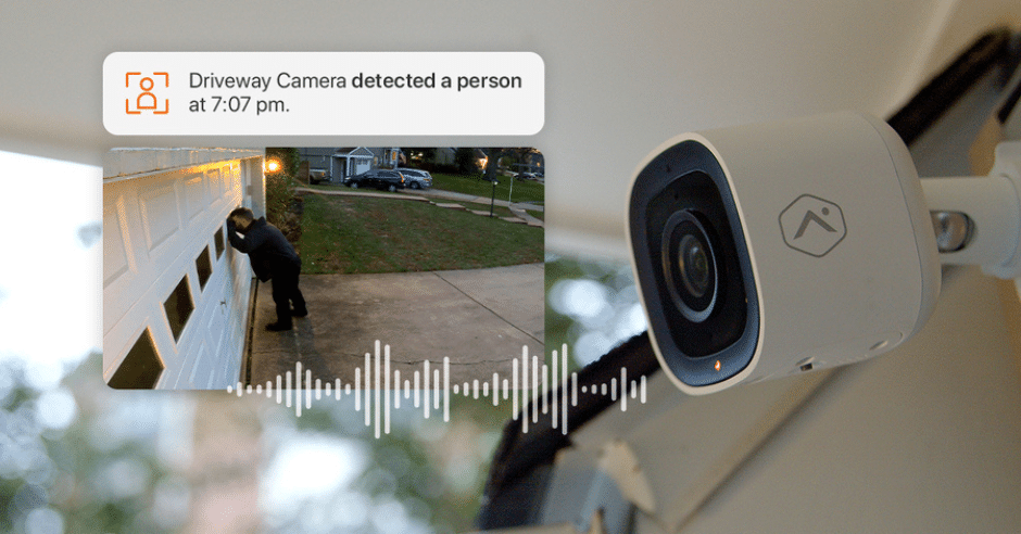 Driveway security camera detecting a person near a garage, with notification alert.