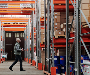 Warehouse employee taking stock of the items on the shelves. Secured by Frase Protection Personal Protection system. 