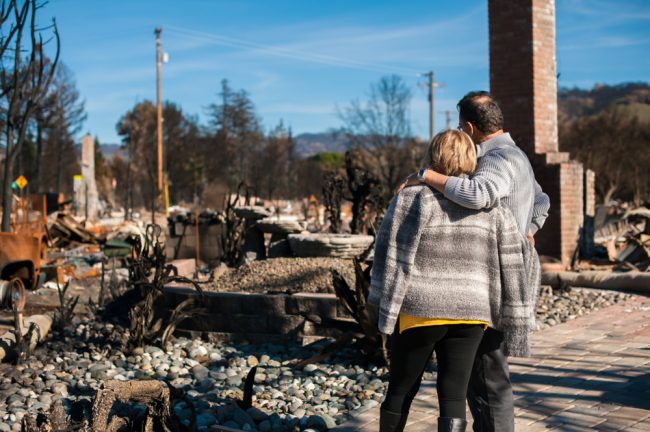 Couple looking at their burned down home